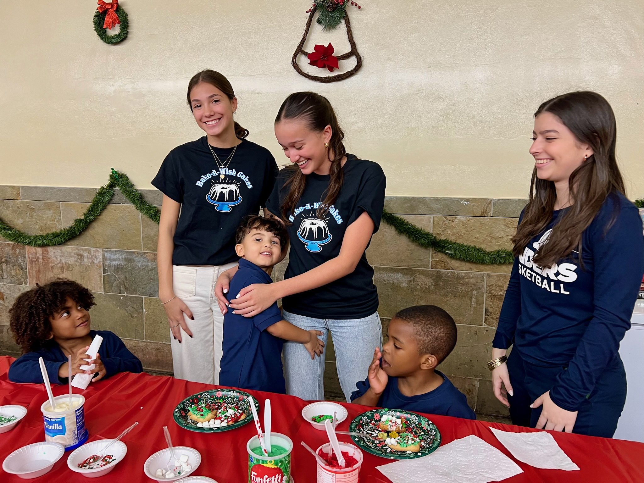 Bake-A-Wish volunteers with children at holiday cookie decorating celebration