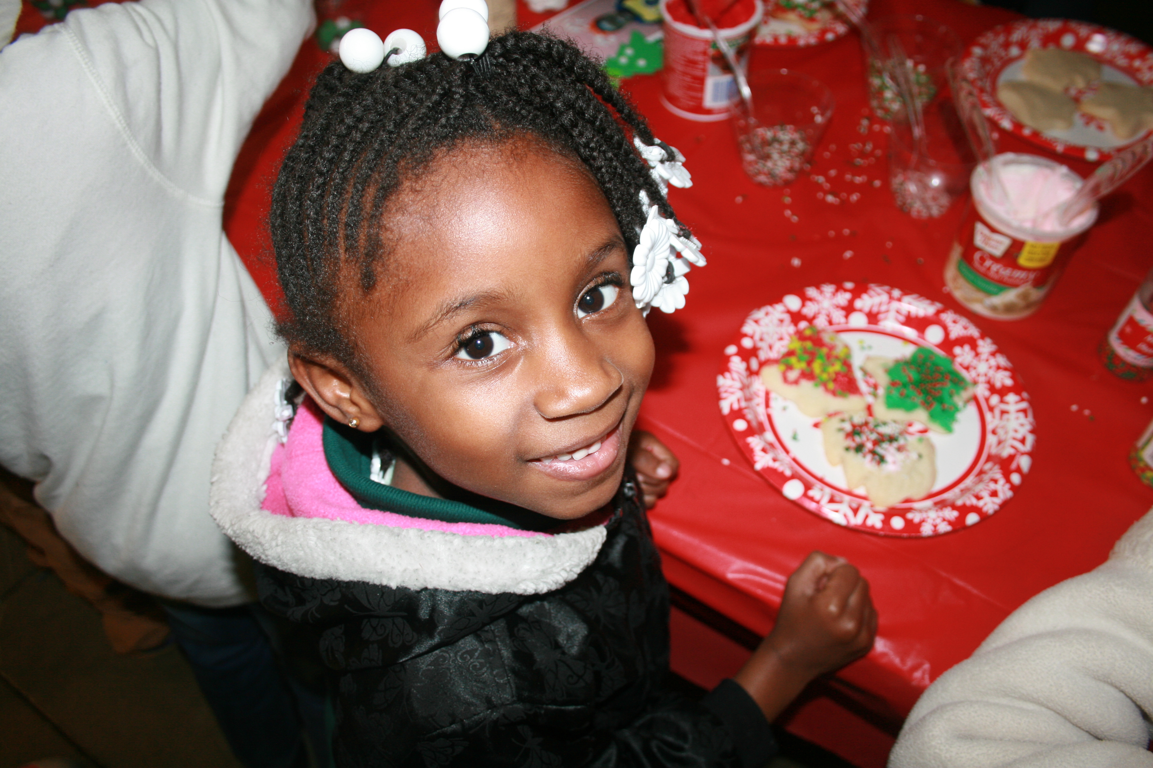 Young girl smiling while decorating holiday cookies