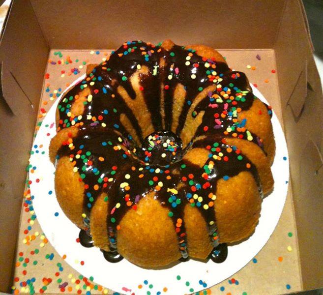 Beautiful bundt cake with chocolate glaze and colorful sprinkles in cake box