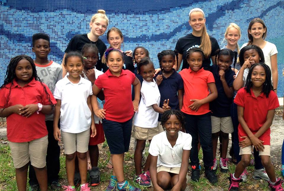Large group photo of Bake-A-Wish volunteers with children in school uniforms outdoors