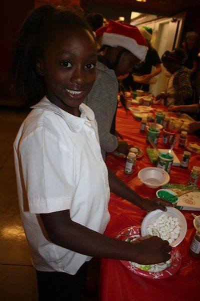 Young girl in white uniform smiling at holiday cookie decorating celebration