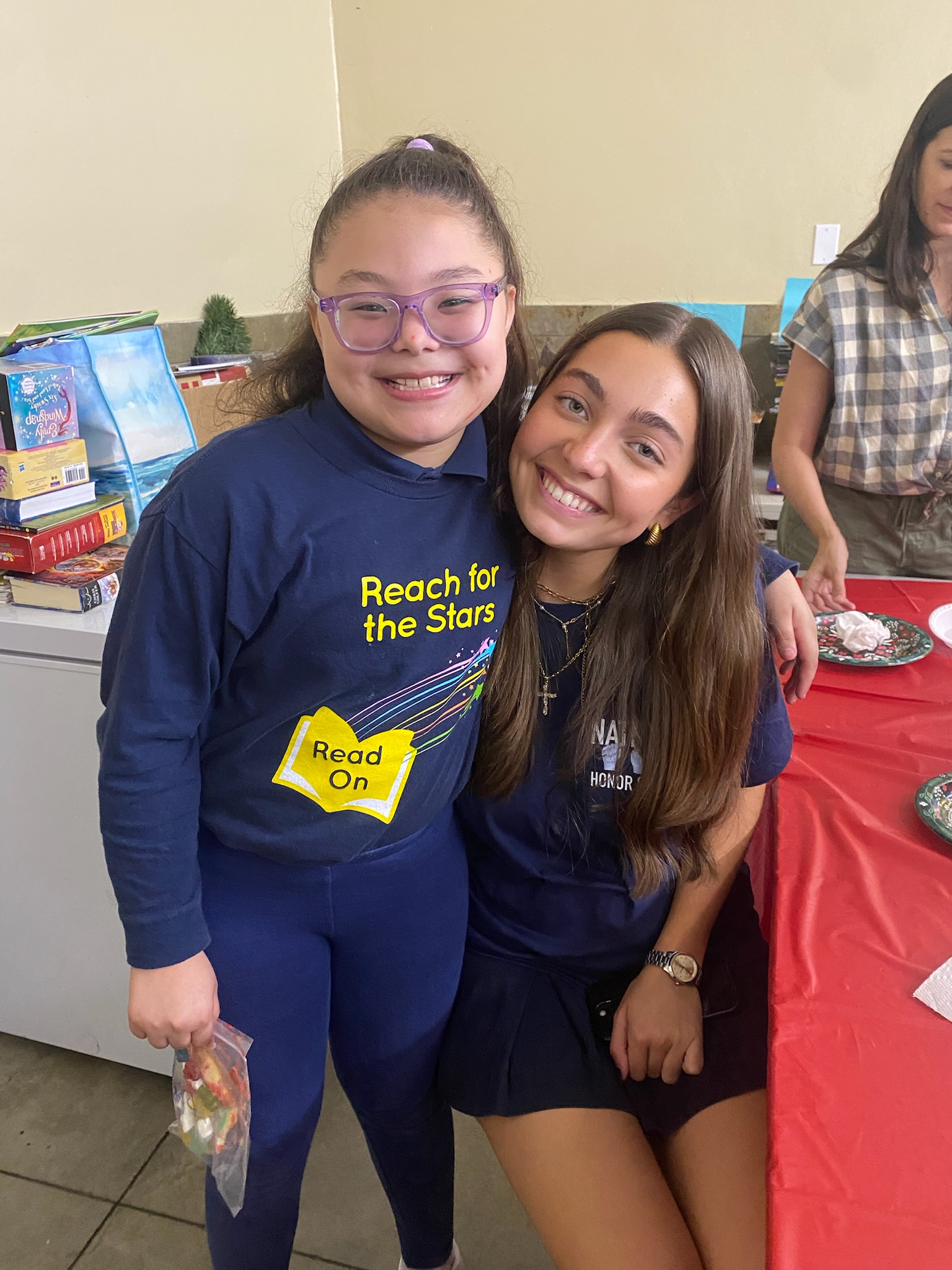 Bake-A-Wish volunteer with child from Read On program at cookie decorating event